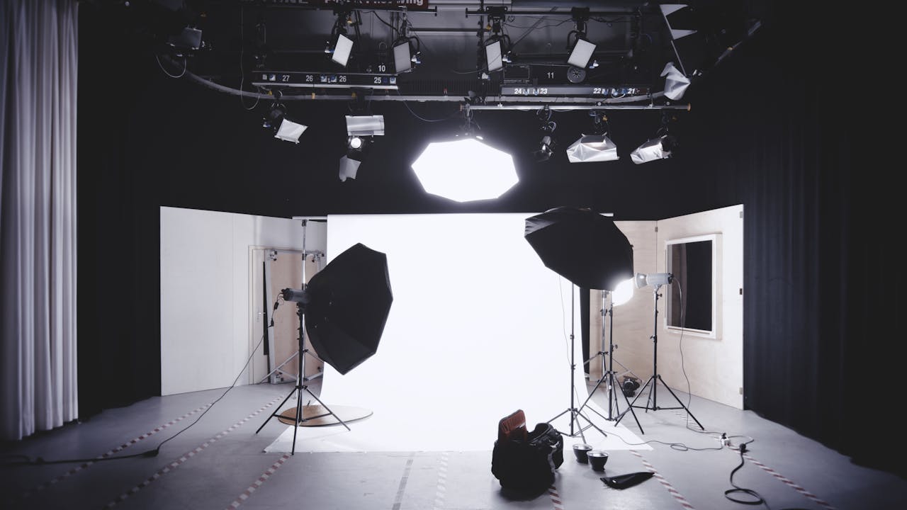 A well-equipped photography studio featuring lights, softboxes, and a white backdrop for professional shoots.